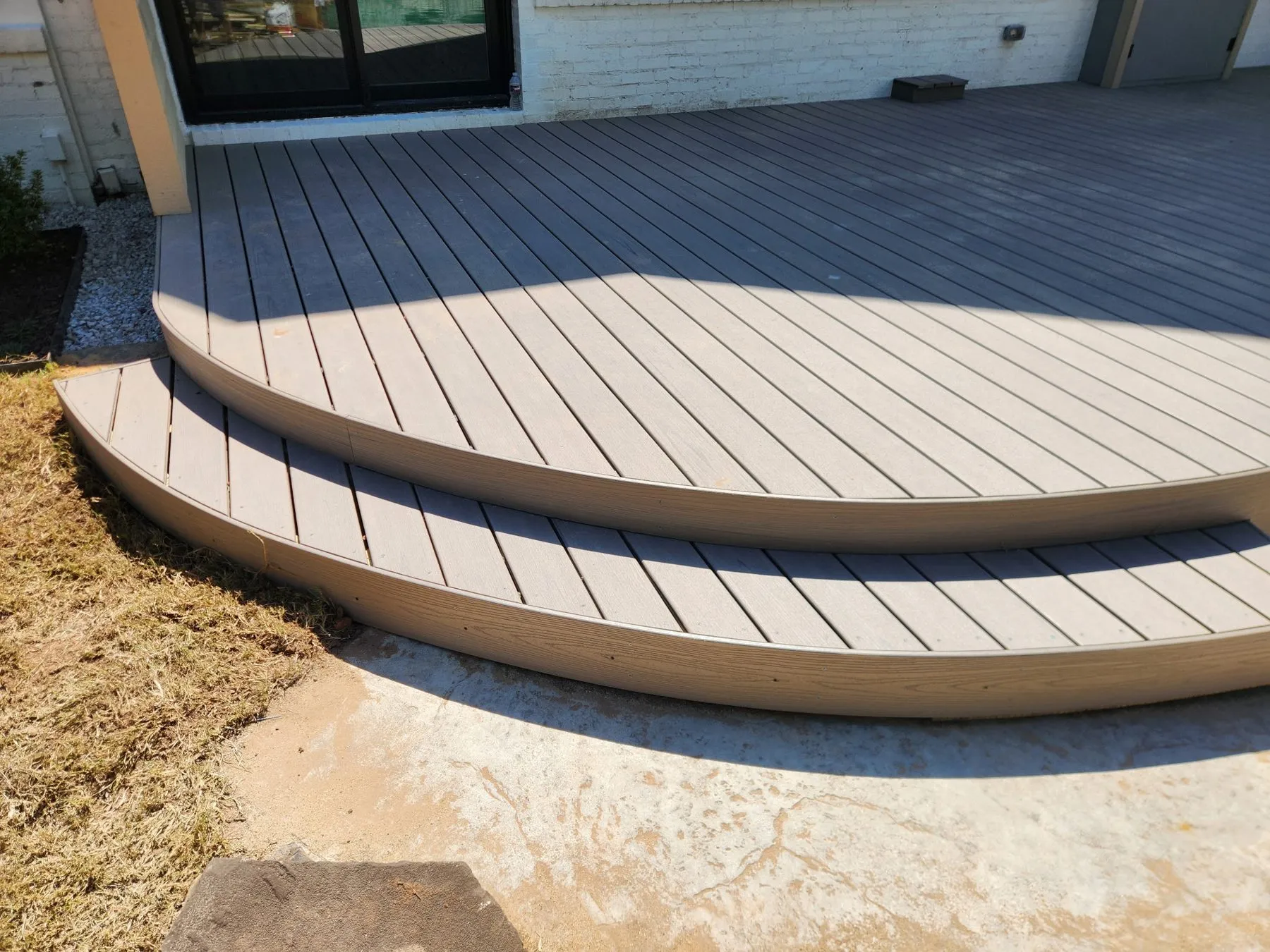 Curved steps on a two-level Trex composite deck beside a pool in Tulsa