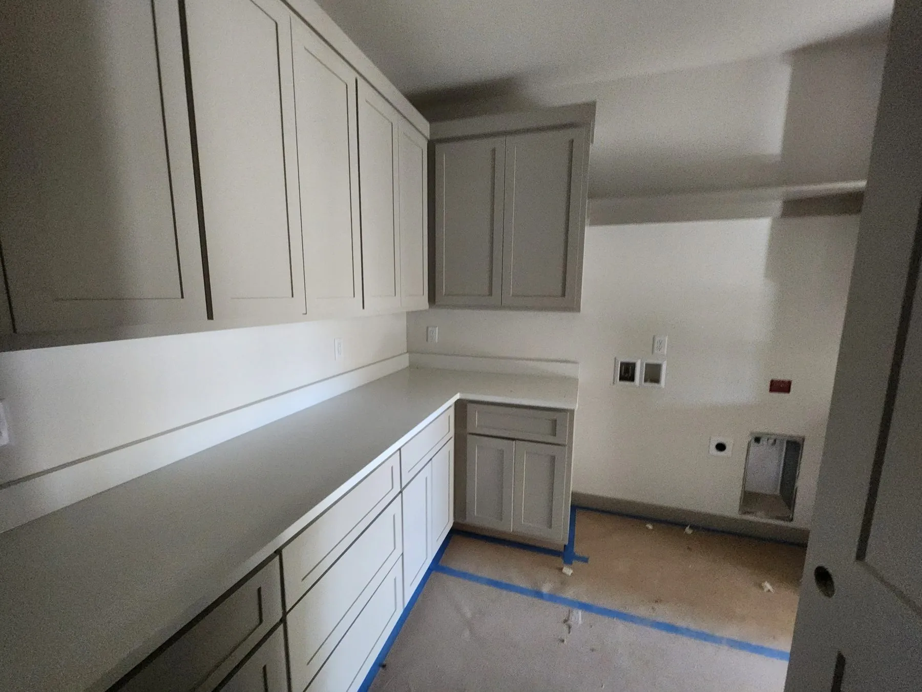 Gray laundry room cabinets and white countertops after a Tulsa interior repaint