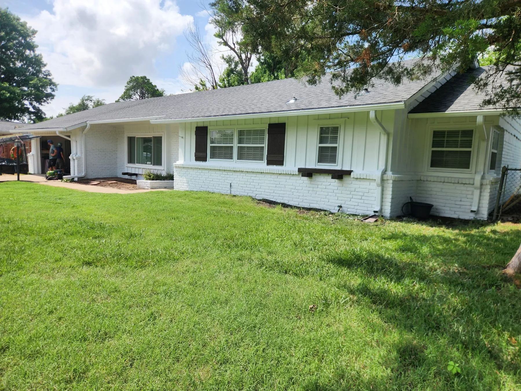 Fresh white siding and black shutters on a Tulsa home repainted inside and out
