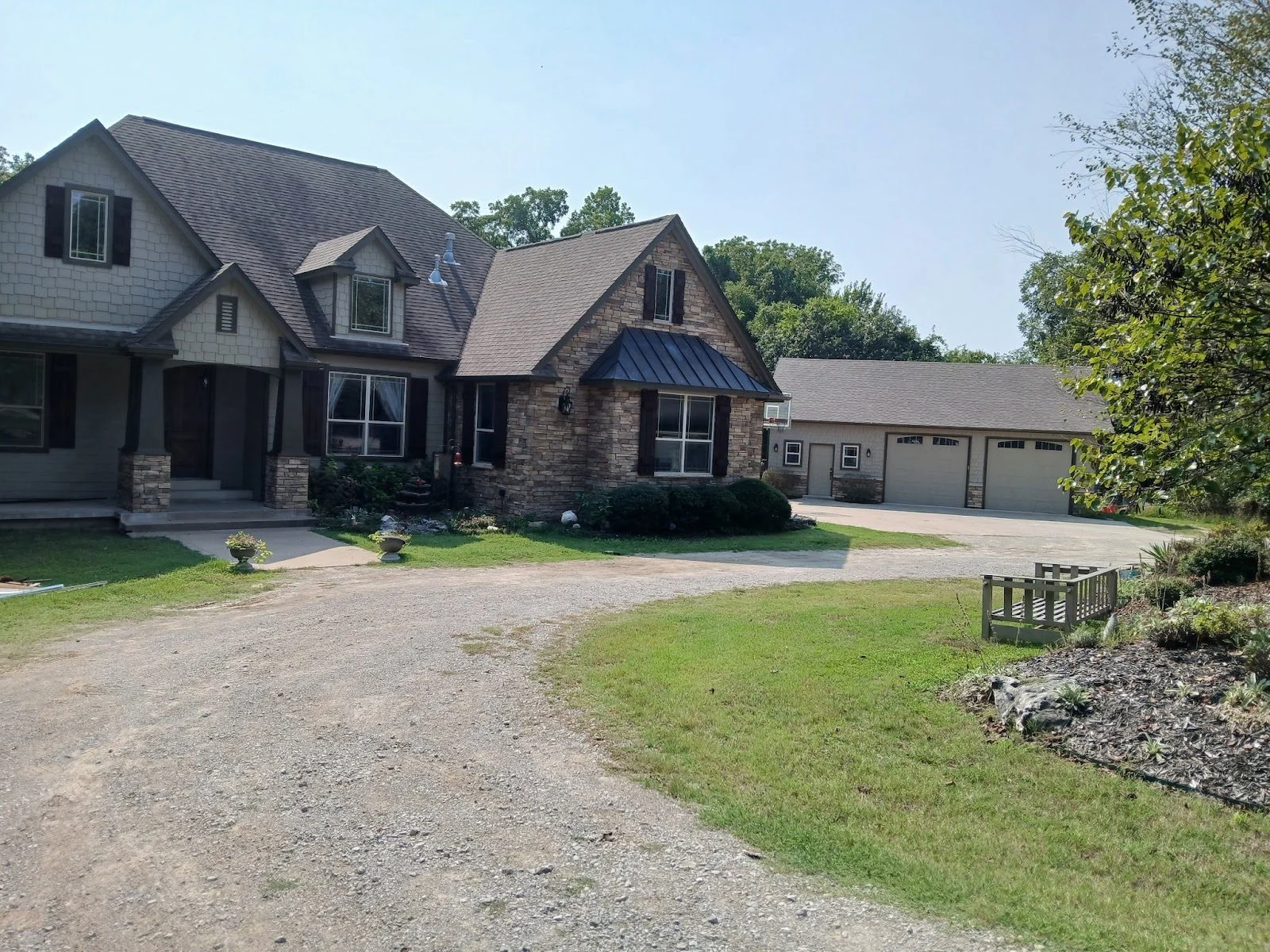 Home with a covered front porch and attached garage after a full exterior repaint in Broken Arrow