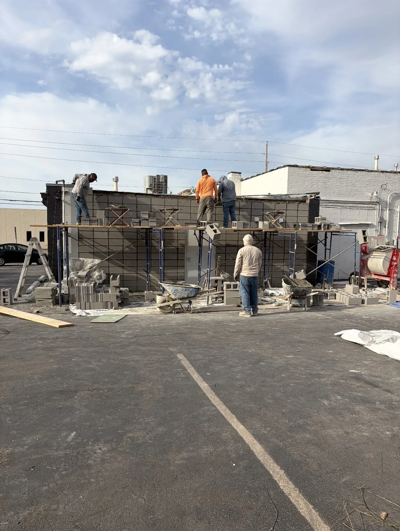 Masonry crew rebuilding a concrete block wall with rebar in the cores at a Tulsa commercial building